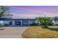 Attractive exterior of a condo with carport and well-manicured lawn at 1305 Glen Oaks E Dr # 130, Sarasota, FL 34232