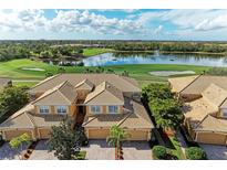 Stunning golf course view with tile roof, lush landscaping, and a tranquil pond at 318 Winding Brook Ln # 104, Bradenton, FL 34212