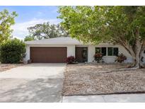 Charming single-story home with a brown garage door, white siding, and landscaped front yard at 346 Suwanee Ave, Sarasota, FL 34243