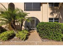 Inviting condo entrance with well-maintained landscaping and a charming arched entryway with a screen door at 207 Rubens Dr # D, Nokomis, FL 34275