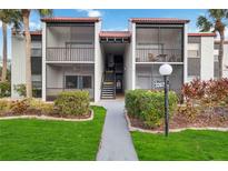 Exterior view of condo building with landscaped grounds at 3267 Beneva Rd # 103, Sarasota, FL 34232