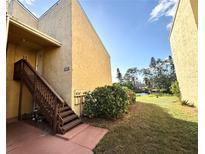 Exterior view of condo building with stairs and landscaping at 3433 Clark Rd # 234, Sarasota, FL 34231