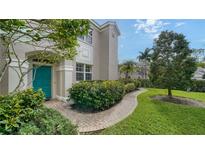 Front exterior of house with teal door and landscaped walkway at 5235 Parisienne Pl # 101B28, Sarasota, FL 34238