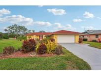 Single-story house with a red tile roof, attached garage, and well-manicured lawn at 1051 N Cypress Point Dr, Venice, FL 34293