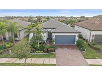 Single-story home with gray roof, gray garage door, and landscaped front yard at 1724 Hyssop Loop, North Port, FL 34289