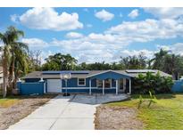 Newly painted blue house with solar panels, basketball hoop, and landscaped yard at 2332 Pinehurst St, Sarasota, FL 34231