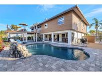 Stunning outdoor pool with a rock feature and spacious patio, perfect for relaxation and entertaining at 521 Cummings St, Sarasota, FL 34242