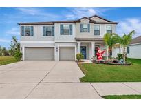 Two-story home with a two-car garage and landscaped lawn at 7404 Mill Hopper Ct, Palmetto, FL 34221