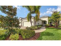 Landscaped front yard with palm trees and walkway leading to the house entrance at 7616 Alumni Trl, Sarasota, FL 34243