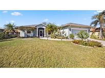 Single-story home with a landscaped lawn and attached garage at 2421 Yalta Terrace, North Port, FL 34286