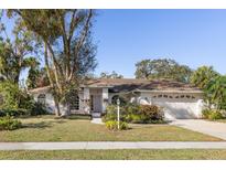White single-story house with a two-car garage and mature landscaping at 4498 Diamond E Cir, Sarasota, FL 34233