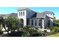 Beautiful home featuring a stucco exterior, arched entry, pergola and attractive landscaping with mature trees and plantings at 4742 Balboa Park Loop, Bradenton, FL 34211