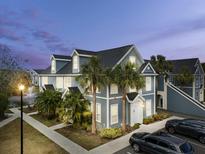 Two-story townhome with gray siding, white trim, and palm trees at 5560 Rosehill Rd # 201, Sarasota, FL 34233