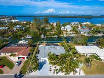Aerial view of waterfront home with private dock and lush landscaping at 671 Emerald Harbor Dr, Longboat Key, FL 34228