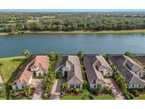 Stunning aerial view of waterfront homes with mature trees and lush landscaping at 7115 Callander Cv, Lakewood Ranch, FL 34202