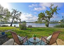 Relaxing lake view featuring outdoor seating area, beautiful blue skies, and lush green landscaping at 9514 Colonial Dr, Bradenton, FL 34210
