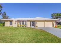 Single-story home with attached two-car garage, well-manicured lawn and a covered patio at 109 Rubens Dr, Nokomis, FL 34275