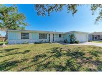 Ranch style home with light blue exterior, white garage door, and well-manicured lawn at 1777 Pomelo Dr, Venice, FL 34293