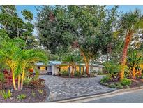 Beautifully landscaped home featuring circular paver driveway and lush tropical foliage at 730 40Th St, Sarasota, FL 34234