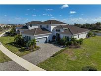 Luxury home with paver driveway and lake view in a community at 5035 Kiva Cir, Bradenton, FL 34211