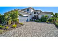 Two-story house with gray paver driveway and lush landscaping at 5035 Kiva Cir, Bradenton, FL 34211