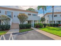 Exterior view of condo building with landscaping and walkway at 5242 Wedgewood Ln # 62, Sarasota, FL 34235