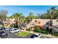 Inviting two-story condo complex featuring palm trees, a well-maintained lawn, and ample parking on a sunny day at 527 Spring Lakes Blvd, Bradenton, FL 34210