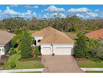 Single-story home with tile roof, two-car garage, and landscaped yard at 963 River Wind Cir, Bradenton, FL 34212