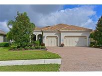 Charming two-car garage home featuring a well manicured lawn, lovely landscaping and a paver driveway at 963 River Wind Cir, Bradenton, FL 34212
