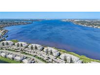 Aerial view of waterfront condo building with parking and lush landscaping at 1010 Tidewater Shores Loop # 103, Bradenton, FL 34208