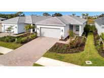 Single-story home with gray tile roof, attached garage, and landscaped front yard at 10426 Abaco Falls Dr, Englewood, FL 34223