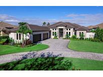 Luxury home with three-car garage, paver driveway, and lush landscaping at 19405 Ganton Ave, Lakewood Ranch, FL 34202