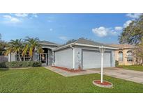 Single story home with attached garage, landscaping, and palm trees at 1860 Summer Walk Cir, Sarasota, FL 34232