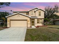 Two-story house with attached garage and landscaping at 26100 Paysandu Dr, Punta Gorda, FL 33983