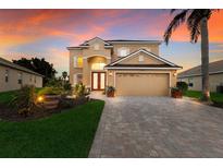 Two-story house with a tan exterior, two-car garage, and landscaped yard at 3618 Summerwind Cir, Bradenton, FL 34209