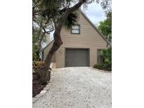 Tan house with gray garage door and gravel driveway at 5311 Creek Dr, Sarasota, FL 34231