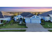 Stunning curb appeal! This beautiful blue home features a welcoming porch and lush landscaping at 13930 Old Creek Ct, Parrish, FL 34219