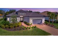 Exterior of a single-story home with a gray garage door and landscaped yard at 15415 Derna Ter, Bradenton, FL 34211