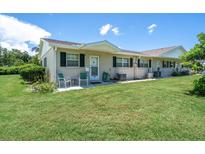 Tan house with green accents and a small front patio at 2771 Golf Course Dr # 101, Sarasota, FL 34234
