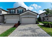 Two-car garage, paver driveway, and landscaping at 6055 Worsham Ln # 104, Lakewood Ranch, FL 34211