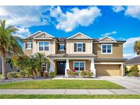 Inviting two-story home featuring a well-maintained lawn, lush landscaping, and a two-car garage at 6318 Anise Dr, Sarasota, FL 34238