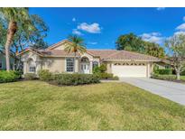 Single-story home with tile roof, attached garage, and manicured lawn at 8679 Woodbriar Dr, Sarasota, FL 34238