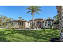 Charming home showcasing the landscaped front yard with palm tree and decorative stone and stucco exterior at 1609 Palm View Rd, Sarasota, FL 34240