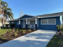 Charming blue home with a fresh driveway and landscaped yard, perfect for curb appeal at 2820 Wood St, Sarasota, FL 34237