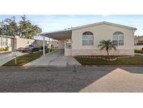 Front view of a manufactured home with carport and landscaped yard at 3386 Oakwood N Blvd, Sarasota, FL 34237