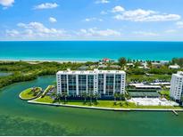 Aerial view of waterfront condo building with pool and tennis court at 9397 Midnight Pass Rd # 906, Sarasota, FL 34242
