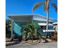 Quaint teal mobile home with palm trees, located in a tropical setting at 10315 Cortez W Rd # 47-2, Bradenton, FL 34210