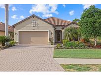 Single-story home with a two-car garage, landscaping, and a brick driveway at 12606 Fontana Loop, Bradenton, FL 34211