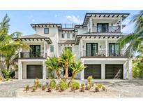 Stunning two-story home with a white exterior, dark trim, and a three-car garage at 129 Mckinley Dr, Sarasota, FL 34236