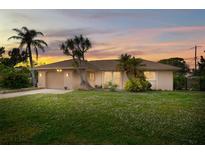 Single-story home with a spacious lawn and attached garage at 1488 Ringtail Rd, Venice, FL 34293